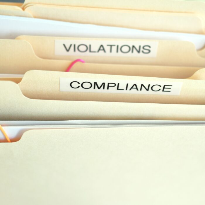 Compliance in the workplace. Folders labeled Compliance, Violations in focus.